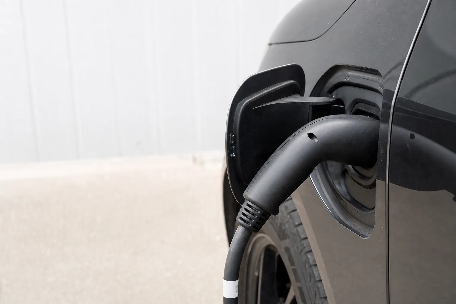 Câble de recharge branché sur la trappe de charge d'un véhicule électrique