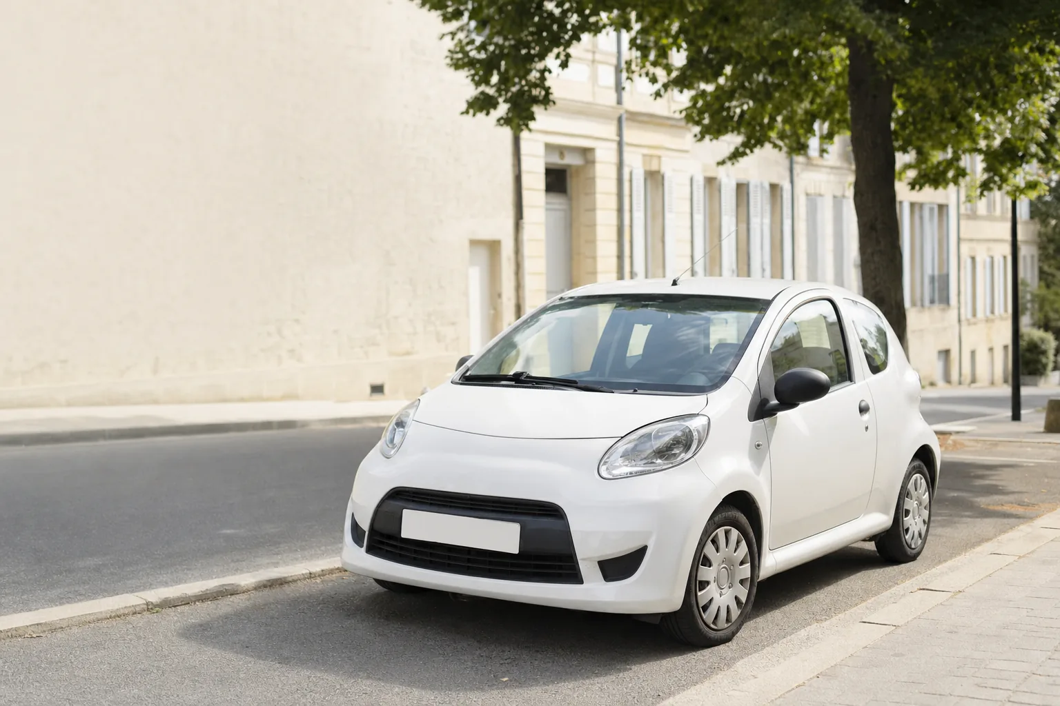 Petite citadine blanche stationnée le long d'une rue résidentielle française