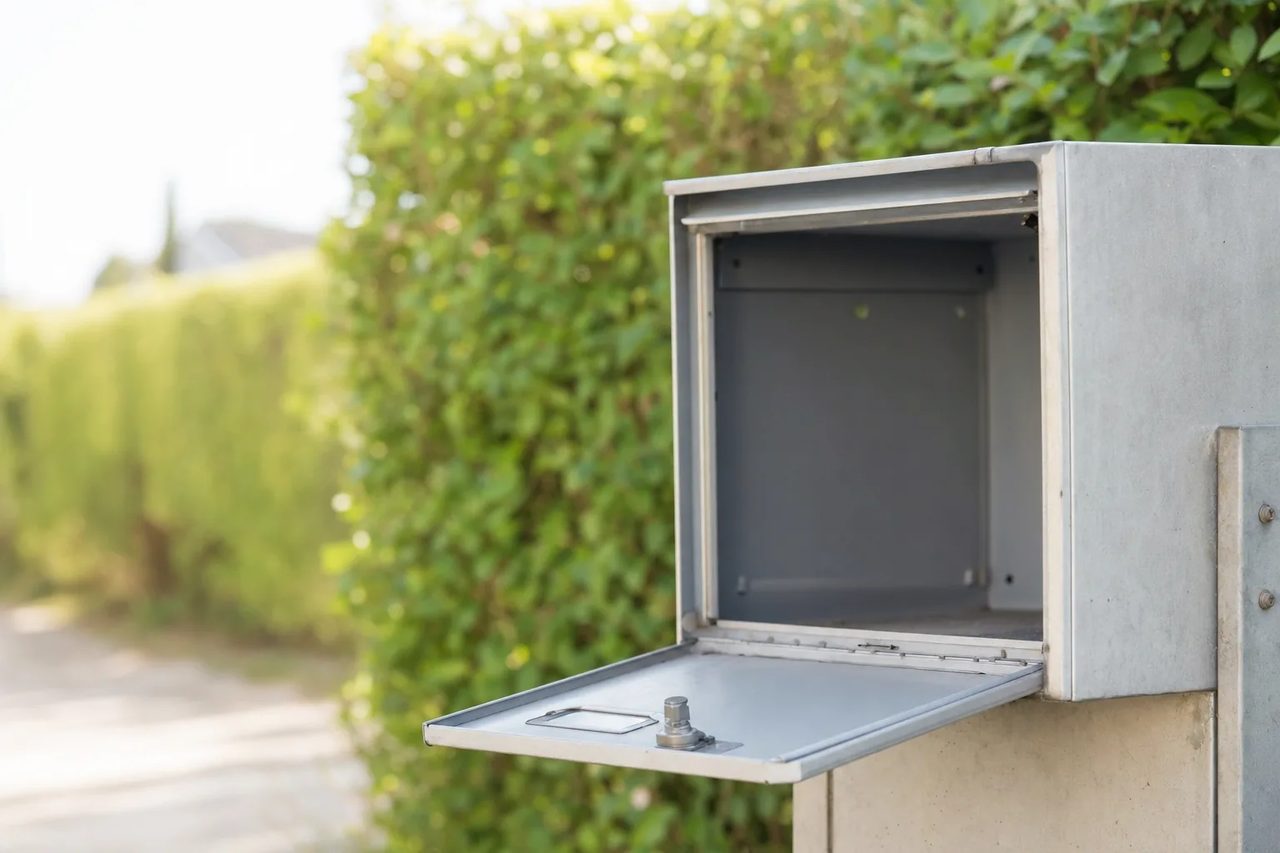 Boîte aux lettres métallique ouverte et entièrement vide, en extérieur