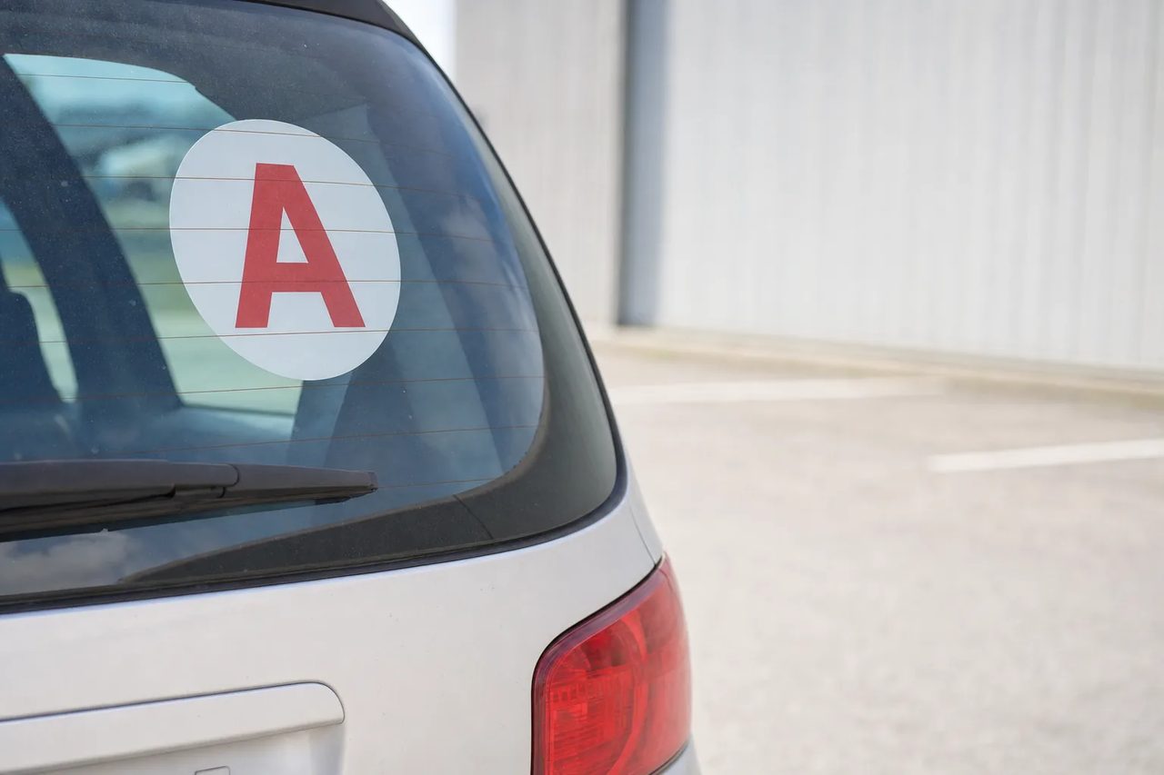 Disque A de conducteur novice collé sur la lunette arrière d'une voiture de location