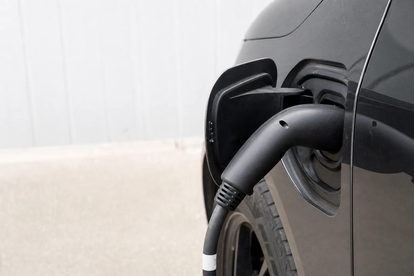 Câble de recharge branché sur la trappe de charge d'un véhicule électrique