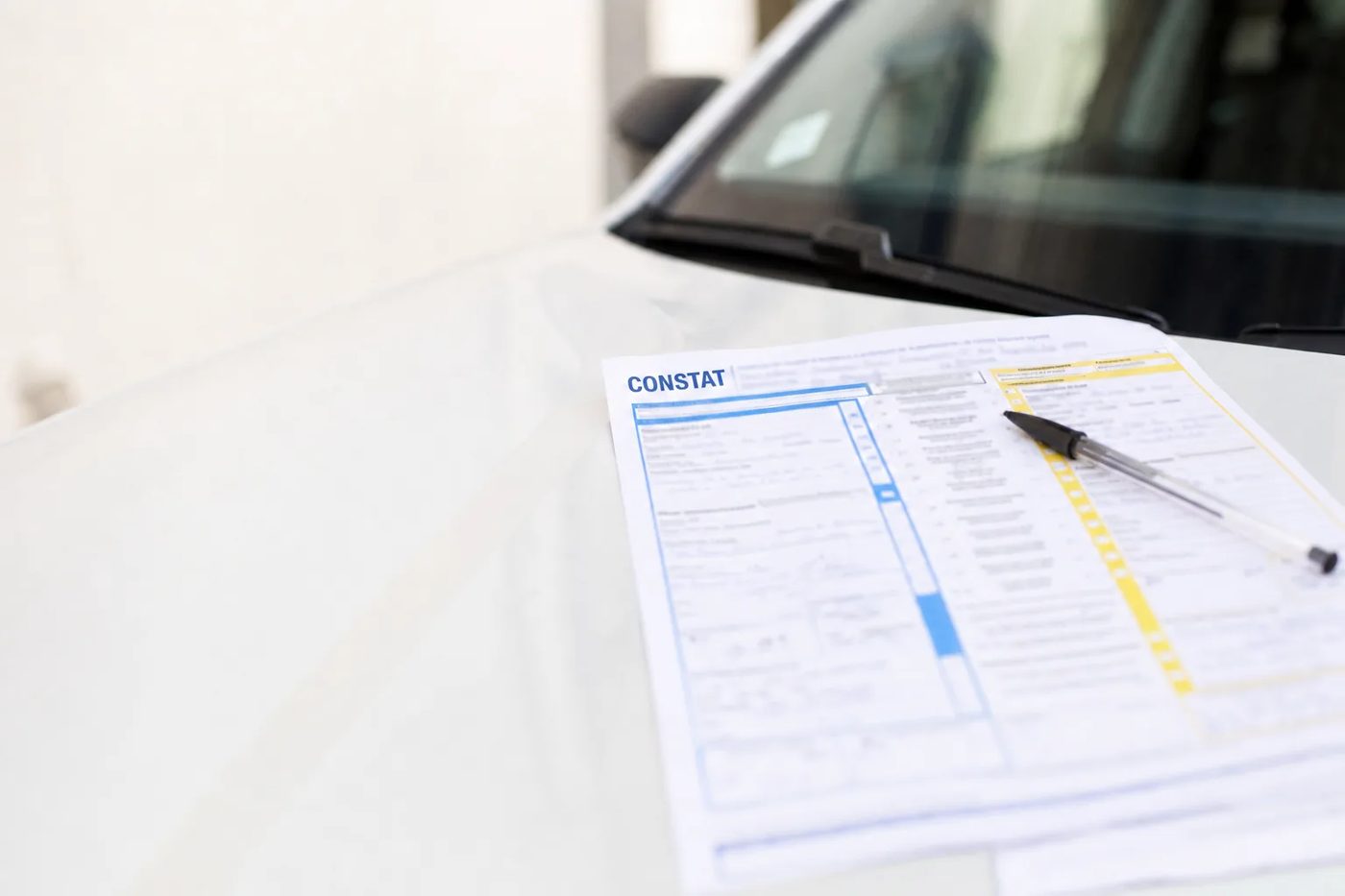 Constat amiable posé sur le capot d'une voiture, tampon CONSTAT